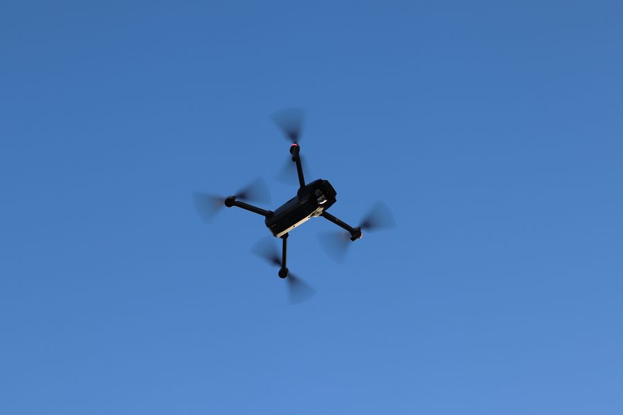 Drone seen from below against a clear blue sky
